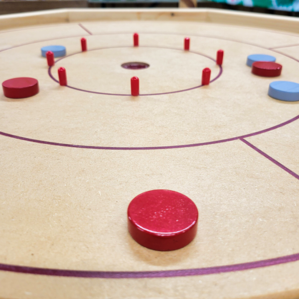 crokinole Handcrafted octagonal Crokinole board with a smooth wooden surface, red scoring pegs, and marked play zones, perfect for family and social gaming
